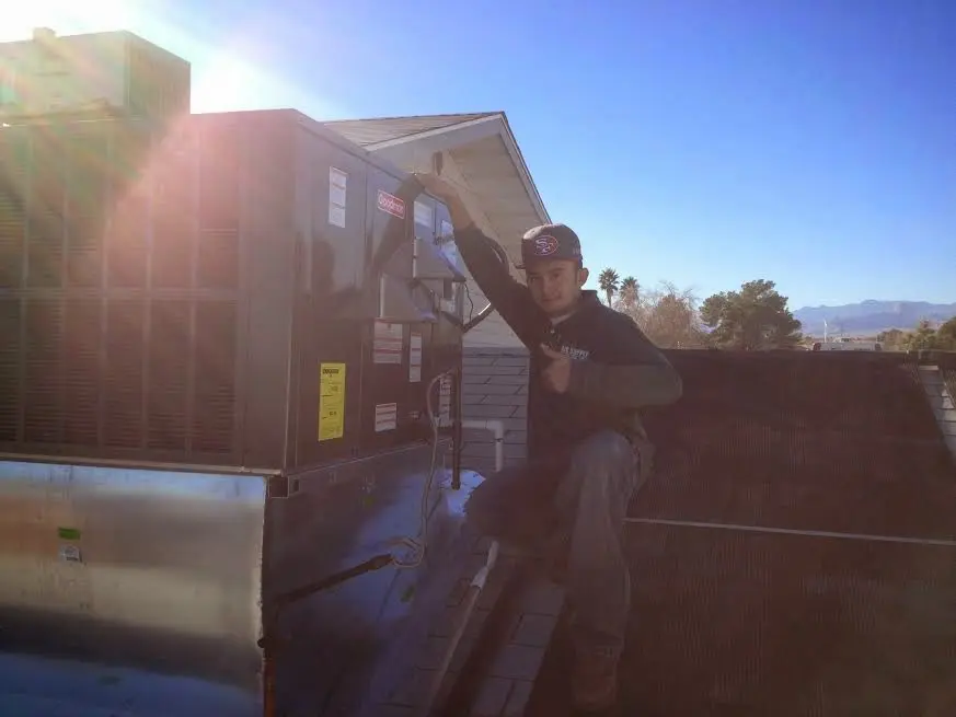 HVAC technician performing Heat Pump Repair on a rooftop unit in Greenwood Village